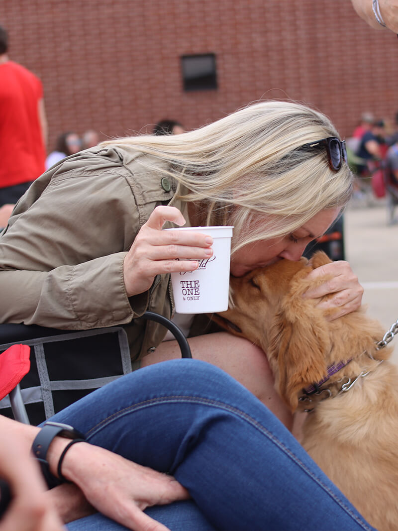 Lady kissing on a dog in Downtown Paragould